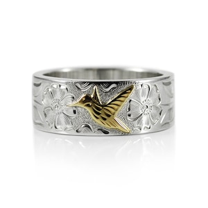 May include: A silver ring featuring a gold hummingbird and flower design.
