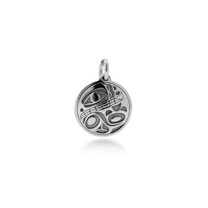 May include: A circular silver pendant featuring an engraved stylised animal design with deep recessed lines. The pendant has a polished metallic finish and includes a small silver jump ring at the top for attachment to a chain or cord.