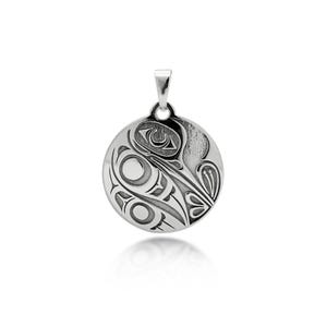 May include: A circular silver pendant with an engraved design. The pendant showcases a stylized bird or animal motif, with curved lines and circular elements. It has a small loop at the top for a chain, typical of a necklace.