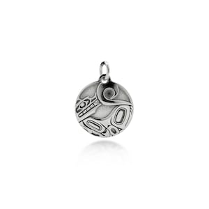 Può includere: Un ciondolo d'argento con un design circolare raffigurante un motivo artistico nativo americano stilizzato. Il ciondolo ha un anello nella parte superiore per una catena. Il design include linee e forme curve, creando un motivo dettagliato e complesso.