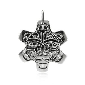 May include: A polished silver-toned metal pendant featuring a stylised, symmetrical face with deep-set eyes, a prominent nose, and a wide mouth. The design includes four radiating, rounded extensions and a small circular bail at the top.