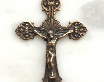 May include: A bronze crucifix with a detailed design and a figure of Jesus Christ on the cross.