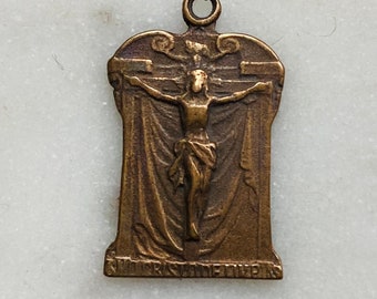 Peut inclure: Pendentif en bronze représentant la crucifixion de Jésus-Christ. Le pendentif comporte une boucle pour l'accrocher et l'inscription "ST. JUDE THADDEUS" en bas. Le pendentif est rectangulaire avec des bords arrondis. Un objet religieux.