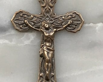 Op de afbeelding: Een bronzen kruisbeeldhanger met een gedetailleerd ontwerp en een figuur van Jezus Christus.