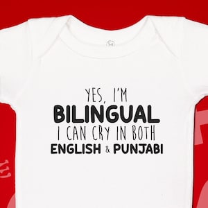 May include: White baby onesie with black text that reads "Yes, I'm Bilingual I can cry in both English & Punjabi".