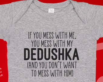 Puede incluir: Un body de bebé gris con el texto "IF YOU MESS WITH ME, YOU MESS WITH MY DEDUSHKA (AND YOU DON'T WANT TO MESS WITH HIM)". El body tiene mangas cortas y corchetes en la parte inferior.