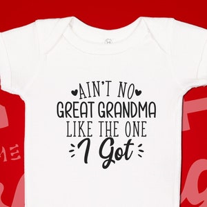 May include: White baby onesie with black text that reads "Ain't no great grandma like the one I got".
