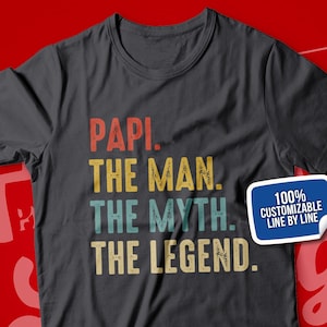 May include: A dark gray t-shirt with the text "PAPI. THE MAN. THE MYTH. THE LEGEND." in a vintage style font. A white sticker with blue text says "100% CUSTOMIZABLE LINE BY LINE".