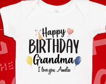 Könnte beinhalten: Weißer Baby Strampler mit dem Text "Happy Birthday Grandma I love you Amelia" in Schwarz. Der Text ist von bunten Luftballons und einer Partymütze umgeben.