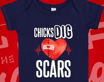May include: Navy blue baby onesie with a white heart graphic and the text "CHICKS DIG SCARS" printed on the front.