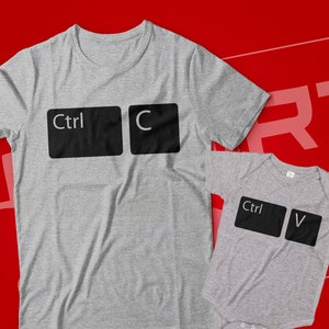 May include: A gray t-shirt with the words "Ctrl C" printed on it, and a gray baby onesie with the words "Ctrl V" printed on it.
