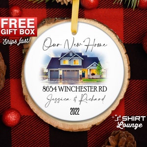May include: A round wooden ornament with a white background. The ornament features a photo of a house with the text "Our New Home", "8654 Winchester Rd", "Jessica & Richard", and "2022".