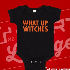 May include: Black baby onesie with the text "What Up Witches" in orange.