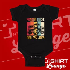 May include: Black baby bodysuit with a colorful graphic of a monster truck. The text "MONSTER TRUCKS ARE MY JAM" is printed above and below the truck illustration in a retro style. The bodysuit has short sleeves and snap closures.