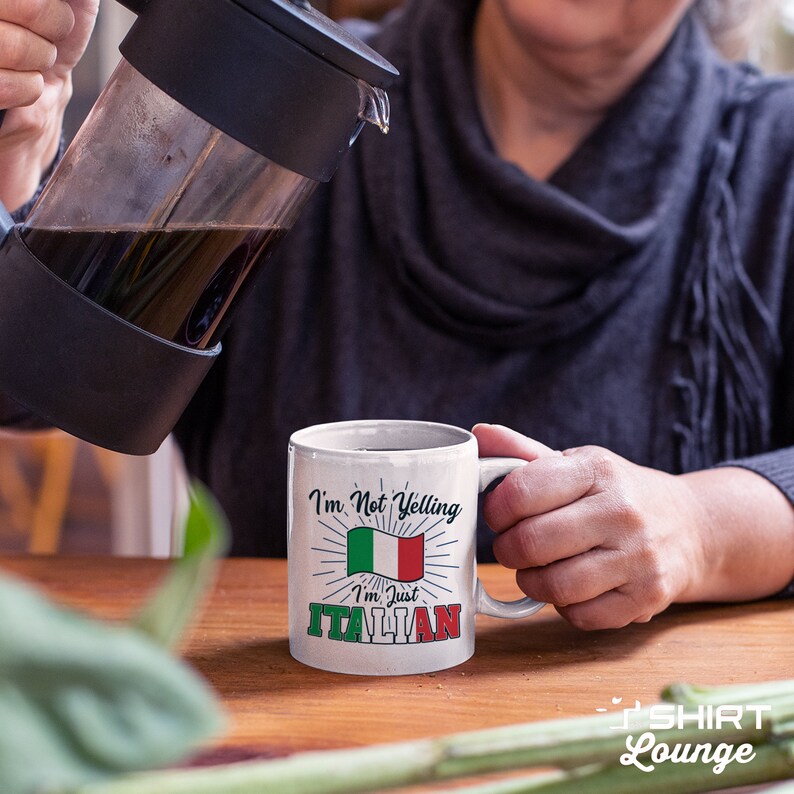 May include: White ceramic coffee mug with a black handle. The mug has a graphic of the Italian flag with the text "I'm Not Yelling I'm Just Italian".