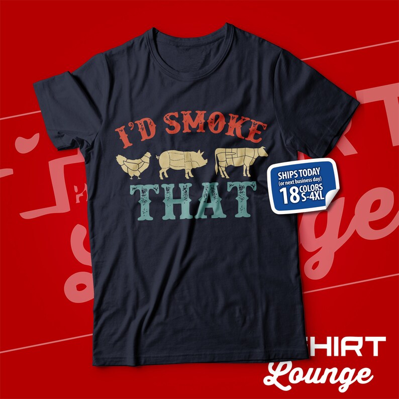 May include: A dark blue t-shirt with the text "I'd Smoke That" in a vintage style font. The text is surrounded by images of a chicken, pig, and cow. The shirt is available in 18 colors and sizes S-4XL.