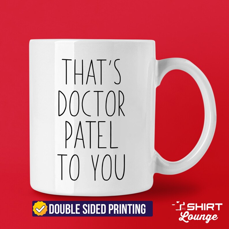 Pode incluir: Caneca de cer&acirc;mica branca com texto preto que diz "That's Doctor Patel to you". A caneca tem uma al&ccedil;a e &eacute; impressa em ambos os lados.