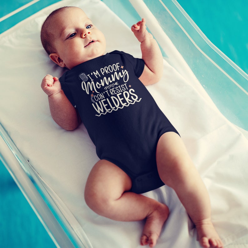 May include: A baby wearing a navy blue bodysuit with the text "I'm proof mommy can't resist welders".
