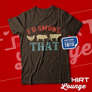 May include: A brown t-shirt with the text "I'D SMOKE THAT" in a vintage style font. The text is surrounded by images of a chicken, pig, and cow. The shirt is available in 18 colors and sizes S-4XL.