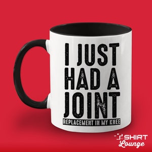 May include: White coffee mug with a black handle and black interior. The mug has black text that reads "I just had a joint replacement in my knee".