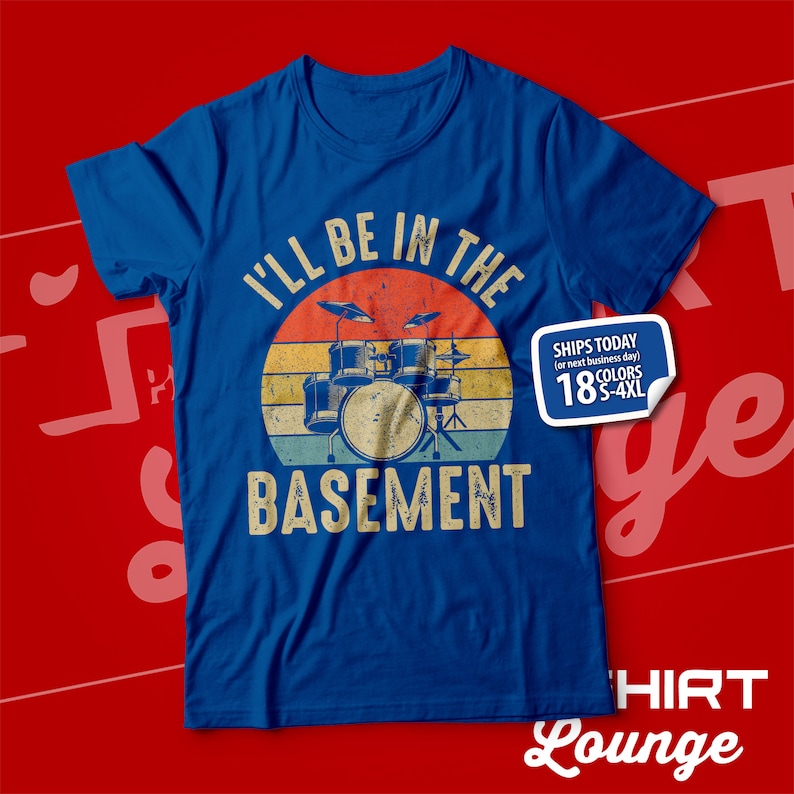 May include: A blue t-shirt featuring a vintage-style graphic of a drum set against a sunset backdrop. The text "I'll be in the basement" is printed beneath the graphic. The t-shirt is available in sizes S-4XL.