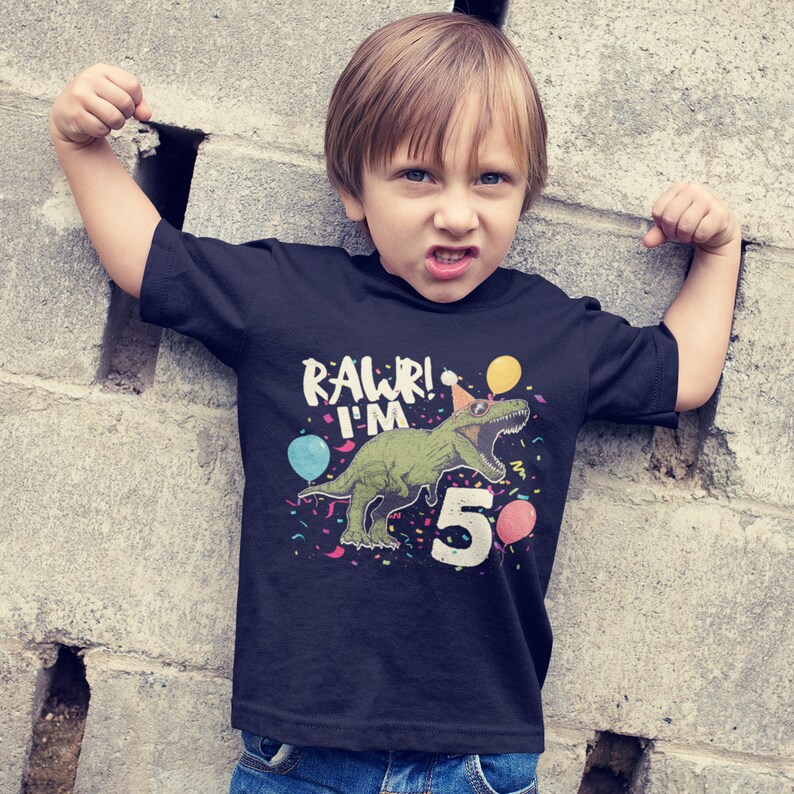May include: A black t-shirt with a green dinosaur wearing a party hat and the text "Rawr! I'm 5" with colorful confetti and balloons.