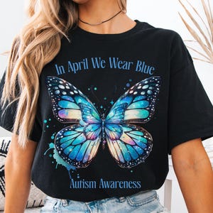 May include: Black t-shirt with a blue butterfly graphic and the text "In April We Wear Blue Autism Awareness".