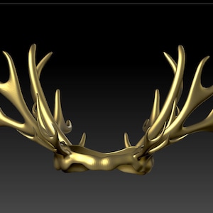 Pode incluir: Uma coroa dourada feita de chifres. A coroa tem uma forma circular com uma superfície lisa e polida.