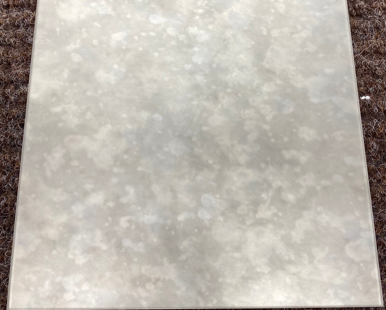 May include: A close-up of a white, textured, rectangular surface with a subtle, mottled pattern. The surface appears to be made of a smooth, reflective material.