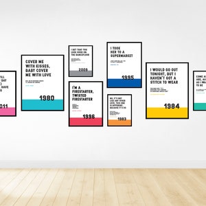 Puede incluir: Una pared blanca con nueve carteles enmarcados, cada uno con una letra de canci&oacute;n diferente y el a&ntilde;o en que se public&oacute;. Los carteles son de varios colores, incluyendo rosa, azul, amarillo y verde.