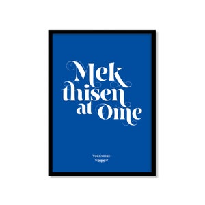 以下が含まれることがあります： 鮮やかな青色の背景に「Mek thisen at Ome」と書かれた白い文字が特徴の額入りアートプリント。下部には「Yorkshire」の文字が印刷されています。プリントは黒いフレームに収められています。