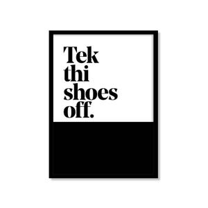 May include: Black and white framed art print. The top half of the print is white, with the words "Tek thi shoes off" in black, bold font. The bottom half is solid black.