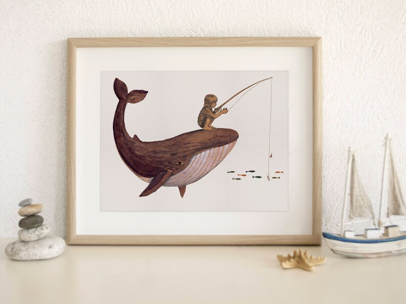 Puede incluir: Una ilustraci&oacute;n enmarcada de una ballena marr&oacute;n con una persona pescando desde su espalda. La ballena nada en un oc&eacute;ano azul claro con peque&ntilde;os peces rojos y naranjas. La persona lleva un sombrero marr&oacute;n y sostiene una ca&ntilde;a de pescar.