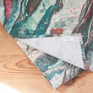 May include: A teal, orange, and white patterned linen table runner with a "Made in Italy" label.