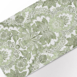 Puede incluir: Una tela con estampado floral verde y blanco con un diseño repetitivo. La tela tiene una textura de lino.