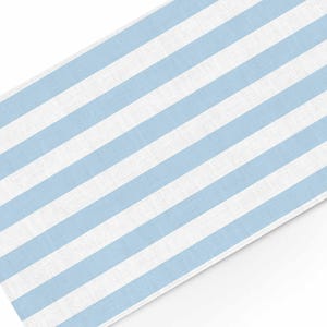Könnte beinhalten: Ein hellblau-weiß gestreifter Stoff, wahrscheinlich eine Tischdecke oder ein Tischläufer, wird diagonal vor einem weißen Hintergrund gezeigt. Die Streifen sind gleichmäßig angeordnet und verlaufen über die Oberfläche des Stoffes.