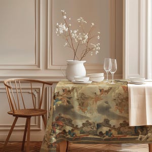 Può includere: Una tovaglia rettangolare con una stampa ripetuta di un dipinto classico raffigurante cherubini e figure in tonalità terra tenui. La tavola è apparecchiata con una brocca in ceramica bianca con fiori bianchi, due calici e ciotole bianche.