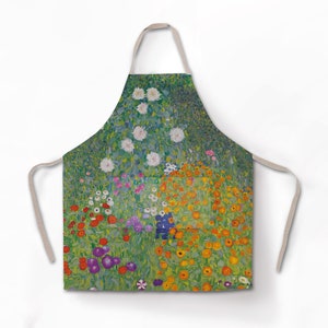 Puede incluir: Un delantal verde con un estampado floral colorido. El estampado presenta flores blancas, naranjas, rojas, moradas y amarillas sobre un fondo verde.
