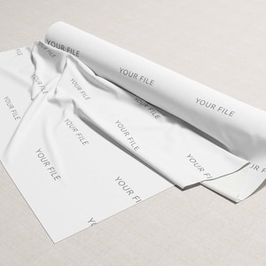 Può includere: Un rotolo di tessuto bianco con il testo "YOUR FILE" ripetuto su tutta la superficie. Il tessuto è arrotolato e l'estremità del rotolo è visibile.