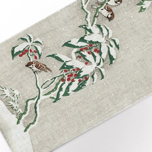 Può includere: Un runner da tavolo in lino bianco con un design floreale verde e bianco e bacche rosse. I passeri sono appollaiati sui rami del design floreale.