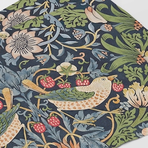 May include: A dark blue fabric with a repeating pattern of stylised birds, flowers, and leaves. The birds are a light brown with green and white accents. The flowers are pink and white with green leaves. The fabric has a vintage aesthetic.