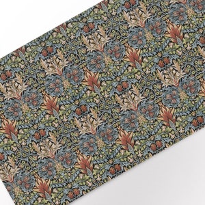 Könnte beinhalten: Ein dekoratives Textil mit einem sich wiederholenden Blumenmuster. Das Design zeigt stilisierte Blumen und Blätter in Rot-, Blau-, Grün- und Goldtönen auf schwarzem Hintergrund. Der Stoff hat eine Vintage-Ästhetik.