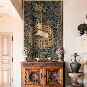 May include: A detailed tapestry showing a white unicorn in a golden enclosure, set against a backdrop of dense foliage. The tapestry is above a carved wooden cabinet. The room has a high ceiling and a classic, elegant design. The cabinet is approximately 150 cm wide.