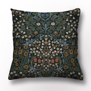 Peut inclure: Un coussin carré avec un fond vert foncé et un motif floral dans les tons de bleu, blanc, rouge et jaune. Le motif présente des fleurs, des feuilles et des vignes stylisées.