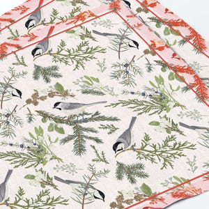 May include: A set of two square cloth napkins with a repeating pattern of gray chickadees perched on branches, surrounded by green foliage and berries. The napkins have a pink border with red accents.