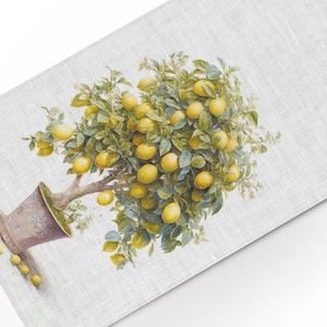 May include: A lemon tree with yellow lemons and green leaves in a brown pot on a white linen background.