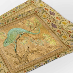 Op de afbeelding: Een groene kameleon die op een tak van een boom zit met gele bladeren. De afbeelding is omlijst met een decoratieve rand van bloemen en wijnstokken.