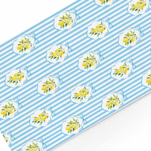 Peut inclure: Un fond rayé bleu et blanc avec un motif répétitif de citrons sur des branches. Les citrons sont jaunes et les branches sont vertes.