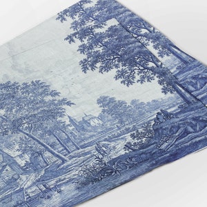 May include: Blue and white toile fabric featuring a pastoral landscape with trees, a river, and a church. The fabric has a detailed, vintage design, reminiscent of classic decorative patterns. The overall theme is a traditional, country aesthetic.