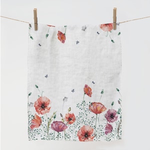 May include: A white linen tea towel with a watercolor floral design featuring red poppies and green foliage.